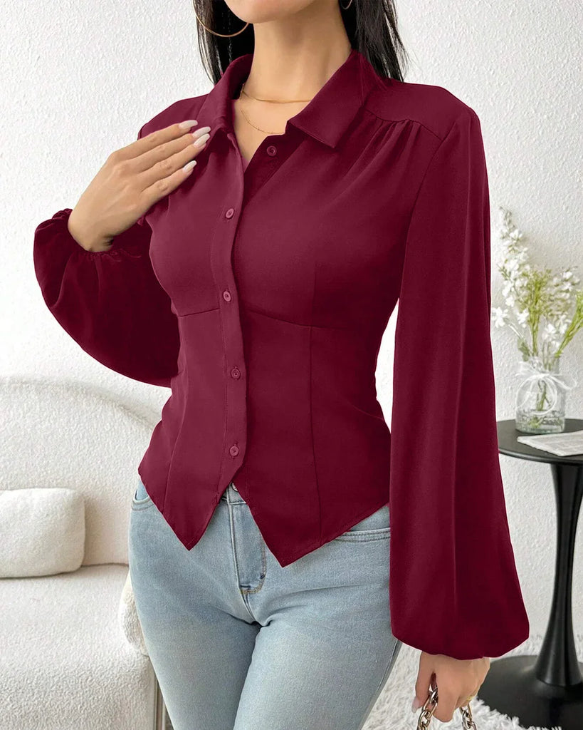 A woman wearing a fitted long sleeve collared button-down shirt in raspberry color.