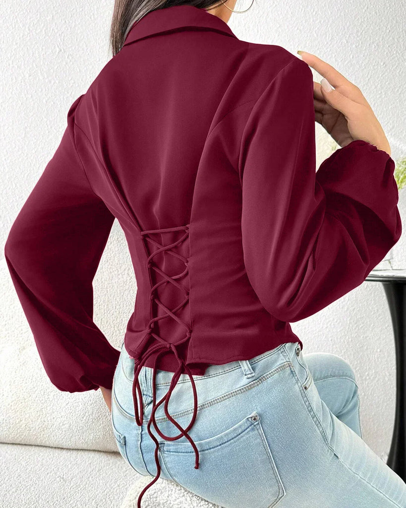 Back view of a woman wearing a fitted long sleeve collared button-down shirt in raspberry color.