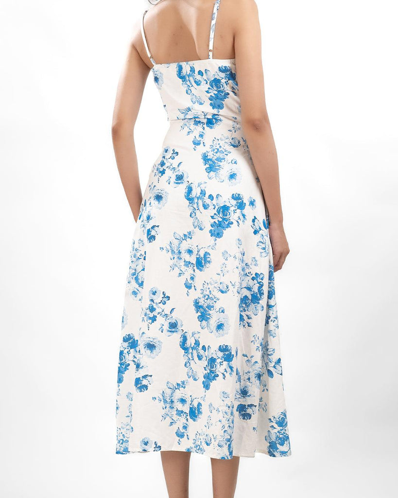 Back View of women wearing cowl neck floral split maxi dress featuring a white and blue floral pattern and a stylish strap design