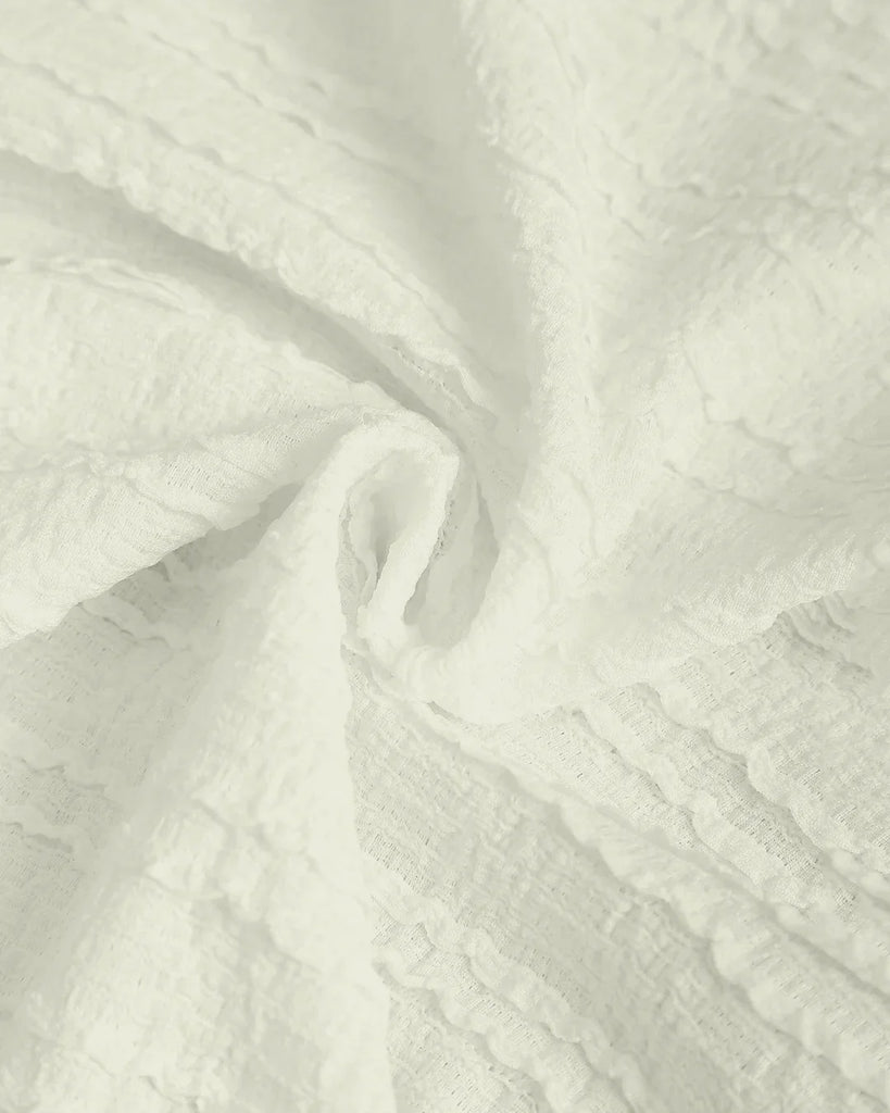 Close up of the fabric of Cream ruched sleeveless tie back top with a stylish detail, perfect for a chic and casual look on a grey background