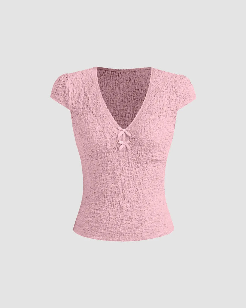Cute baby pink V-neck tee featuring delicate lace trim and a bow, perfect for adding femininity to casual outfits