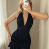 Front view of girls navy blue dress with polka dots, halter neckline and ruffled hem, cute fitted mini style