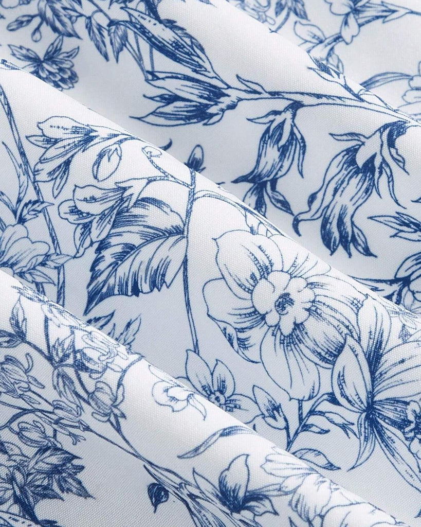 blue and white floral print dress featuring a tie front and puff sleeves, showcasing a stylish and feminine design close up view