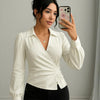 Women wearing v-neck off-white wrap top with dramatic full sleeves and a cinched waist for a structured, elegant silhouette.