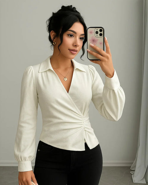 Women wearing v-neck off-white wrap top with dramatic full sleeves and a cinched waist for a structured, elegant silhouette.