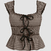 Front view of brown gingham sleeveless top with bow tie front detail and ruffled edges, featuring a fitted waist and flared hem for a cute feminine look