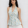 Women wearing white floral halter neck top with knotted waist and flared hem, stylish white floral top.
