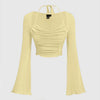 Front view of tie back crop top with ruched front, long flared sleeves and fitted silhouette for a trendy look.