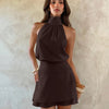 Front view of coffee halter neck mini dress with ruched waist and flared skirt, stylish flare mini dress.