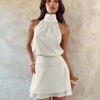 Front view of Off white halter neck mini dress with ruched waist and flared skirt, featuring a soft flowy silhouette
