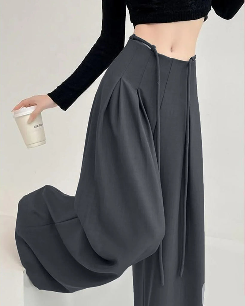 High-waist dark grey wide-leg trousers with a tie-belt and pleated design, suitable for casual or formal wear.