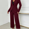 A woman wearing a fitted burgundy blazer and high-waisted trousers, showcasing a stylish and professional outfit.
