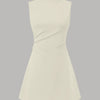 High neck, sleeveless beige mini dress with ruched detailing and A-line silhouette.
