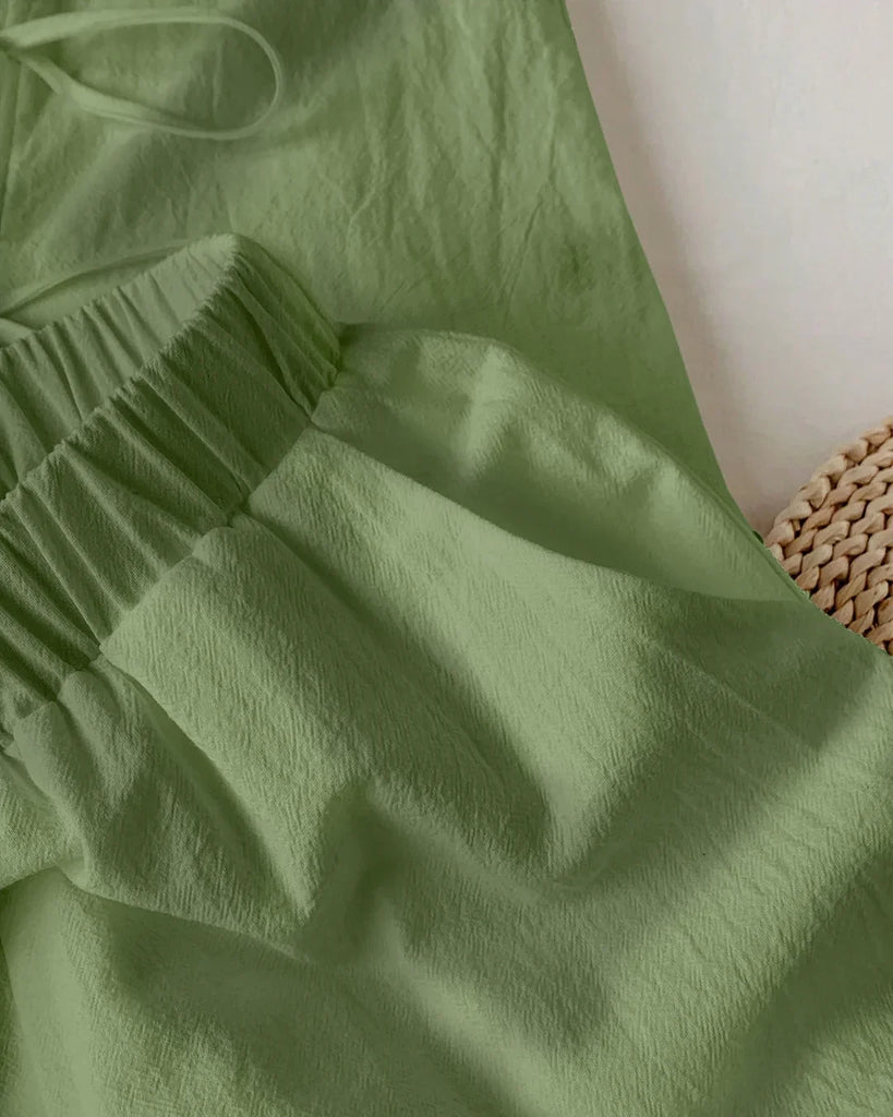 Closed view of a green sleeveless tie-back top and wide-leg pants co-ord set.