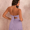 Back view of a lilac strapless ruched bodycon mini dress featuring a ruffle hem, showcasing a stylish and elegant look