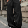 Front view of Black oversized sweat pants for men with drawstring waist, wide legs, and relaxed streetwear fit style.
