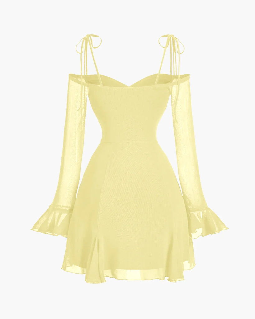 Back view of a Fit & flare dress in French Vanilla with cold-shoulder mesh sleeves, ruffle cuffs, and delicate tie straps for a romantic look.