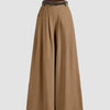 wide-leg trousers with pleats at the waist on a light gray background, showcasing a stylish and relaxed fit