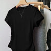 Black short sleeve top with a minimalist design, round neckline, and relaxed fit, displayed on a hanger alongside denim jeans