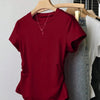  A red top hanging on a rack, showcasing its vibrant color and casual style.