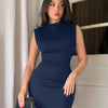 A woman poses confidently in a navy blue sleeveless bodycon mini dress.