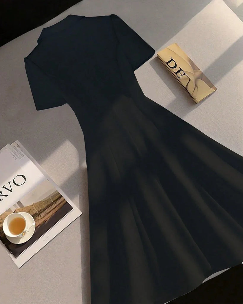 Back view of a Black fit and flare mini dress with a white shirt and shoes, featuring a notch collar and buttoned design.
