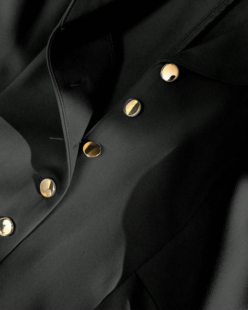 Closed view of a Black fit and flare mini dress with a white shirt and shoes, featuring a notch collar and buttoned design.
