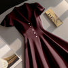 Burgundy fit and flare mini dress with buttons and a book, featuring a notch collar design.