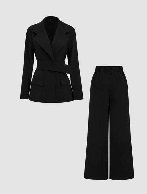A black belted blazer with notched lapels paired with wide-legged black trousers.