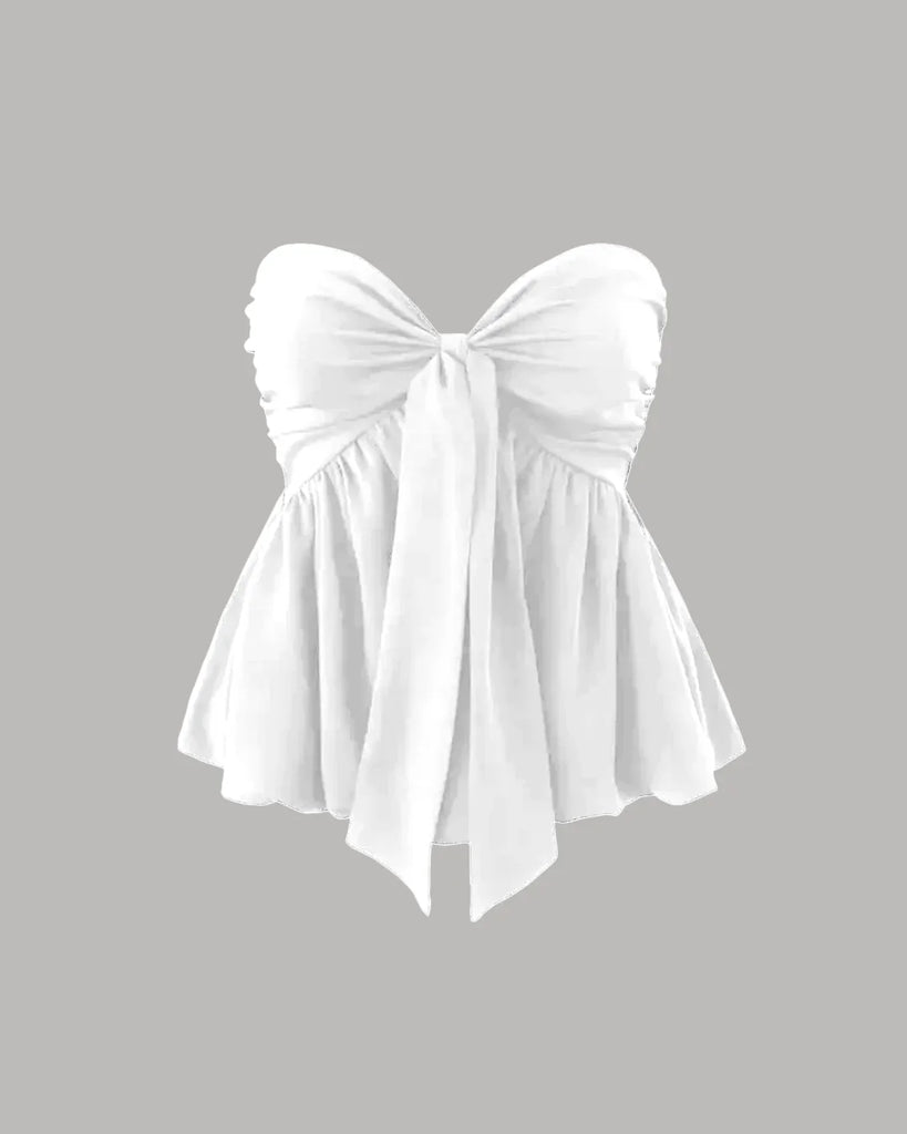strapless peplum Off-white  top featuring a dramatic front-tie bow and a flared hem for a playful, elegant look