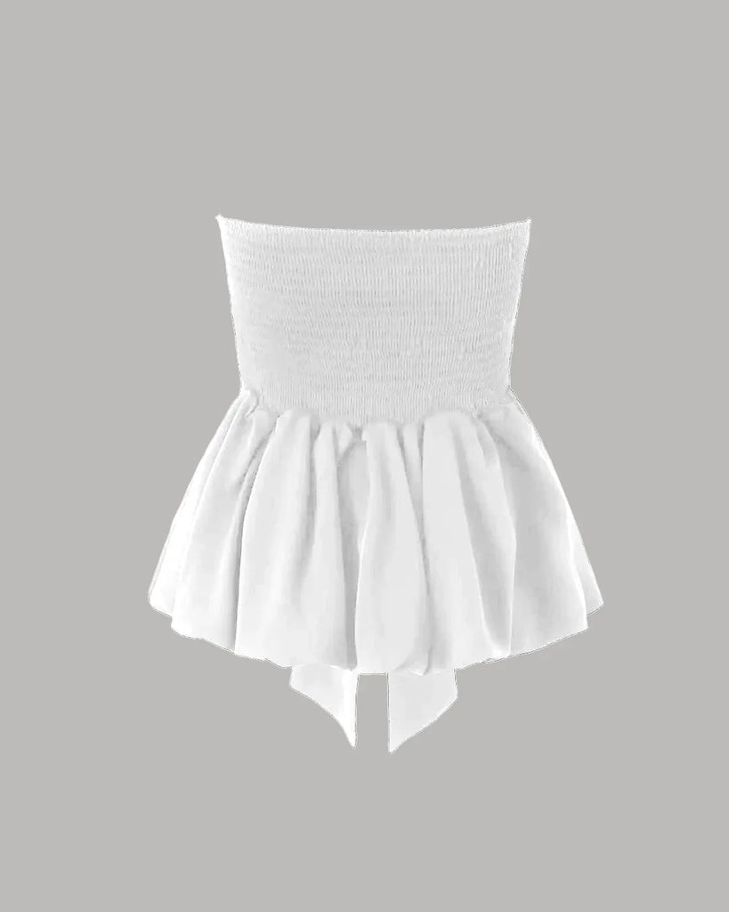 strapless peplum Off-white  top featuring a dramatic front-tie bow and a flared hem for a playful, elegant look on a grey background