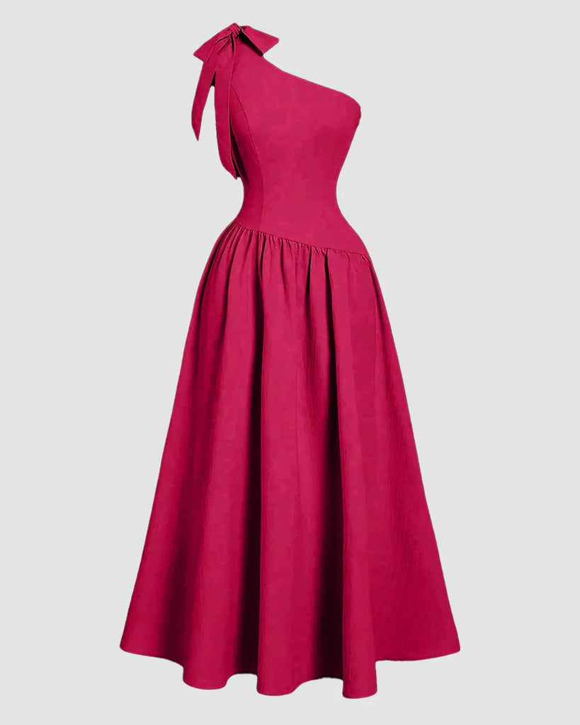 One-shoulder hot pink midi dress featuring a bow detail on the back and a fit-and-flare silhouette.
