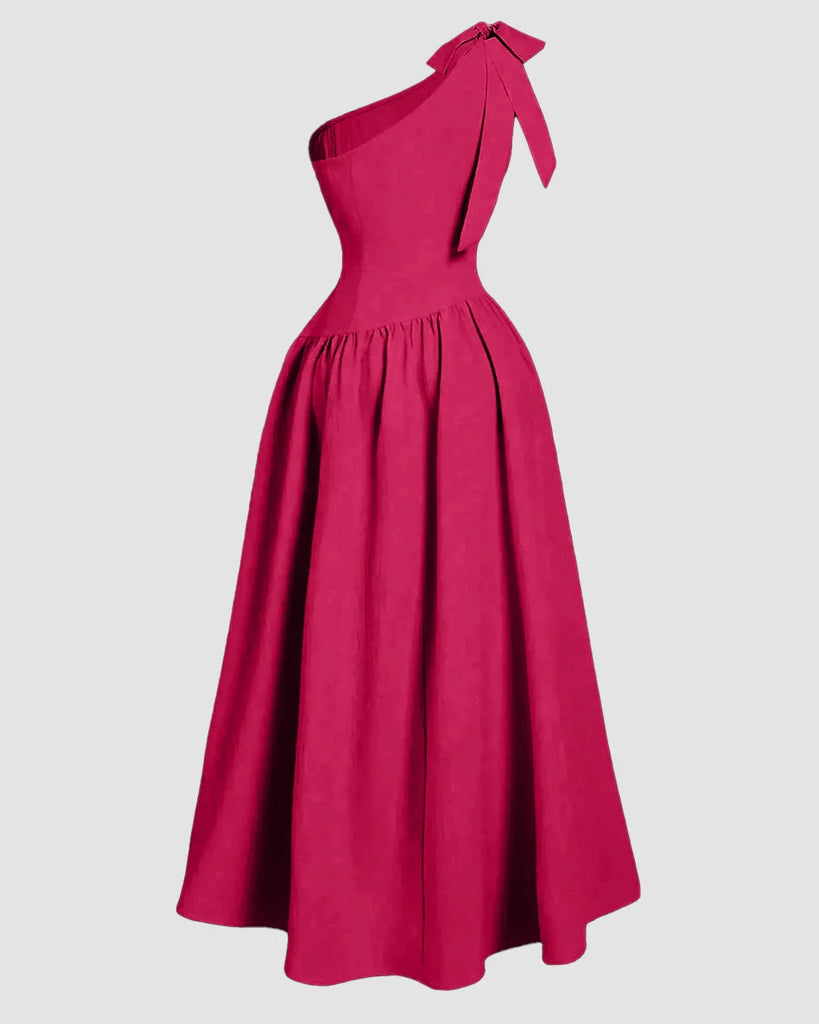 One-shoulder hot pink midi dress featuring a bow detail on the back and a fit-and-flare silhouette.
