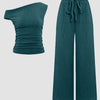 Teal blue one-shoulder ruched top paired with wide-leg trousers in a coordinated set.