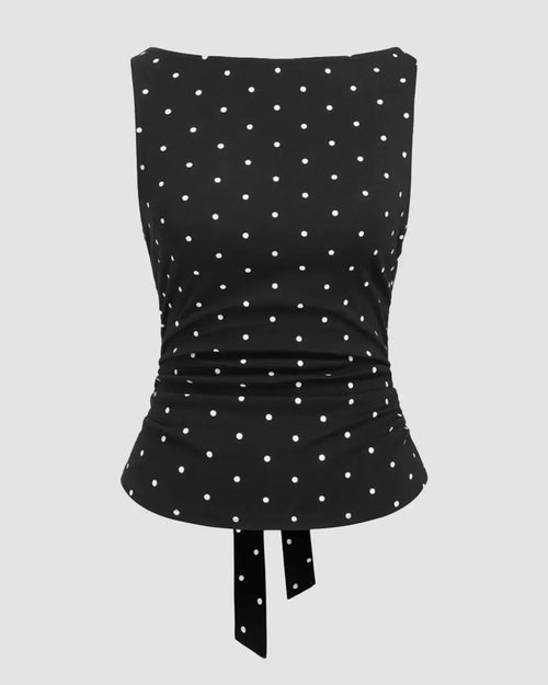 Front view of black polka dot top brings a playful twist with a clean, fitted silhouette.