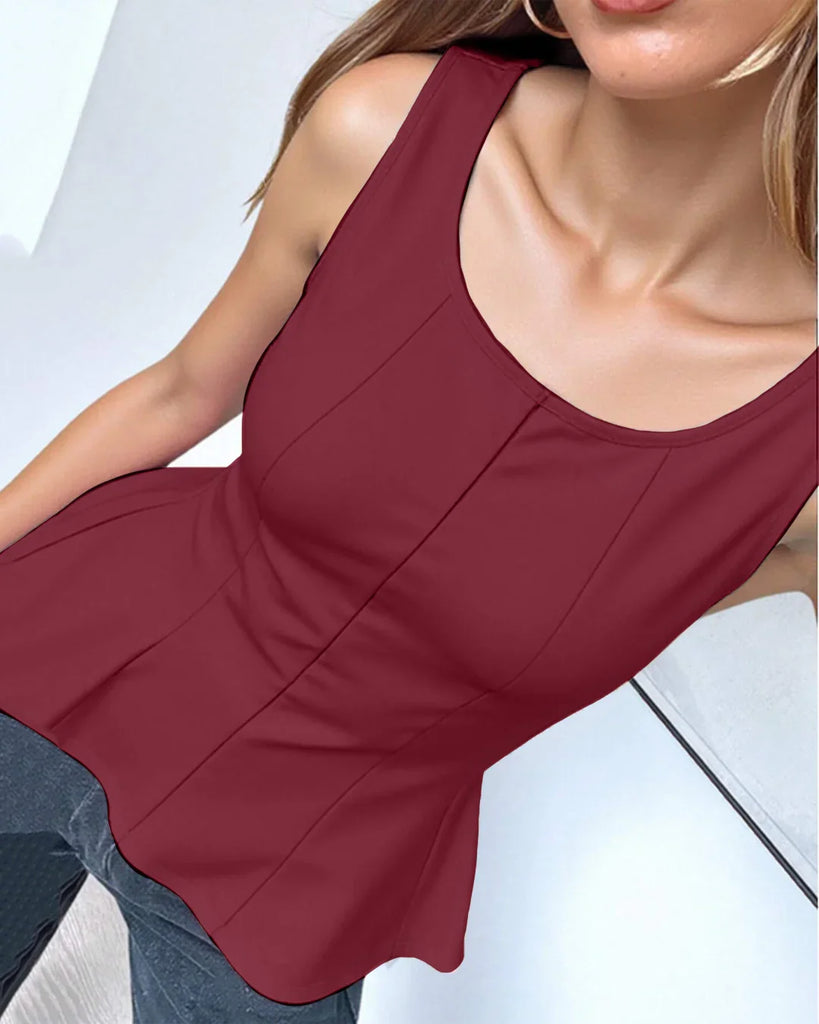 Model in a fitted burgundy peplum top, holding a leopard print bag, showcasing a stylish and trendy outfit.