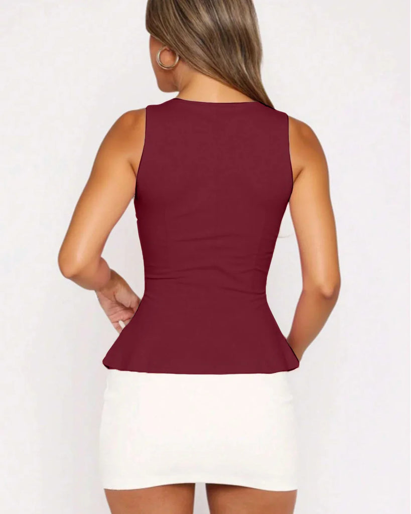 Back view of a Model in a fitted burgundy peplum top, holding a leopard print bag, showcasing a stylish and trendy outfit.