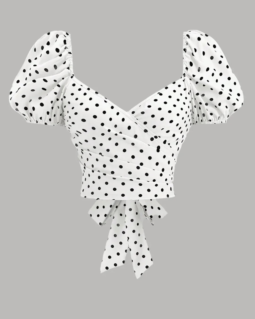 White polka dot puff sleeve wrap top with a bow and ruffle detailing, perfect for a stylish casual look.

