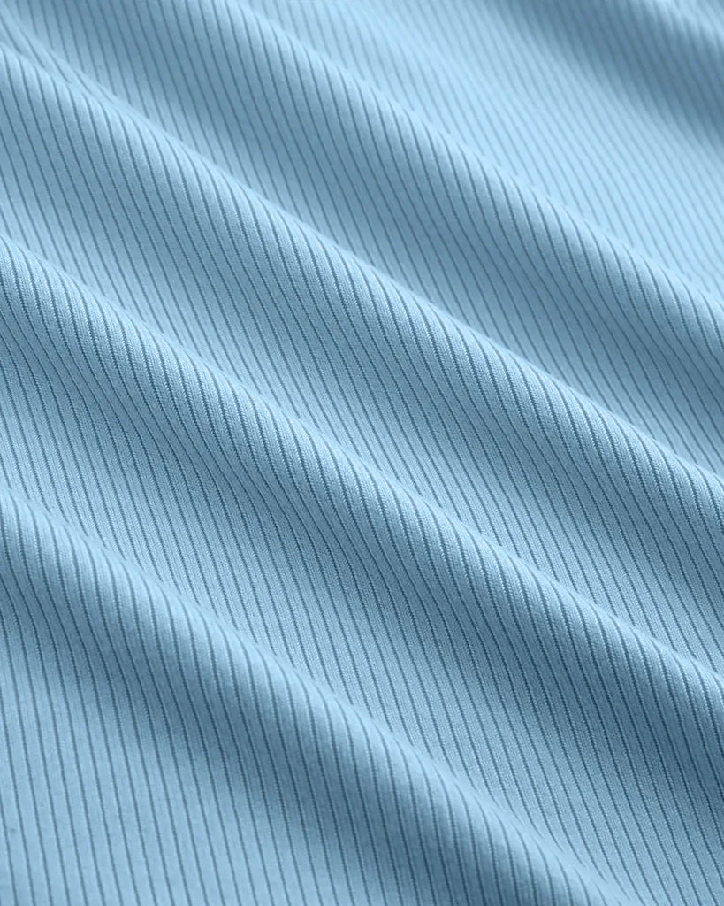 Close up of powder blue fitted top featuring a sheer lace neckline detail, showcasing a stylish and elegant design