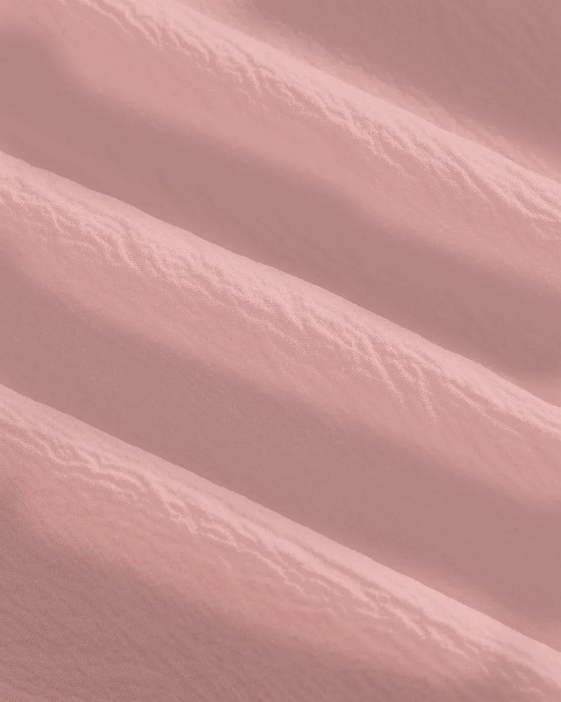 Powder pink off-shoulder dress featuring a faux fishbone design for structured elegance and a romantic, sculpted silhouette.