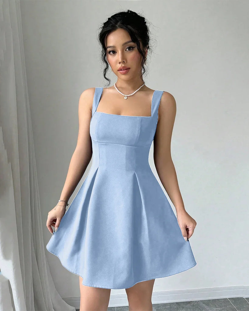  A woman in a light blue Rainwash fit and flare mini dress takes a selfie, smiling at the camera.