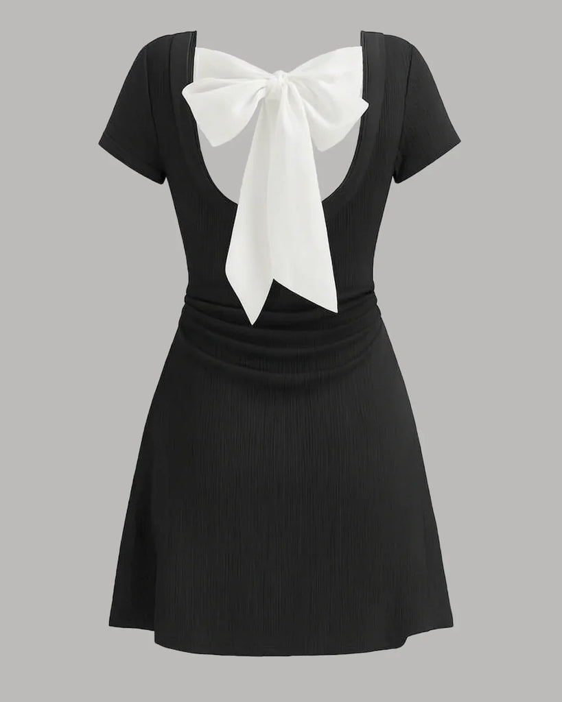 Back view of a Black mini dress with a round neckline, white collar, and bowknot detail, featuring ruched design.