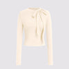 Off-white cropped sweater with a round neckline and long sleeves, featuring a stylish bow tie detail