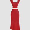 Dark red dress featuring a ruched crop top and a ruffled asymmetric hem skirt.
