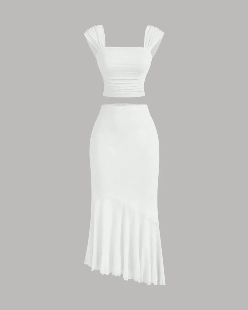  White dress featuring a ruched crop top and an asymmetric hem skirt with a ruffled design.