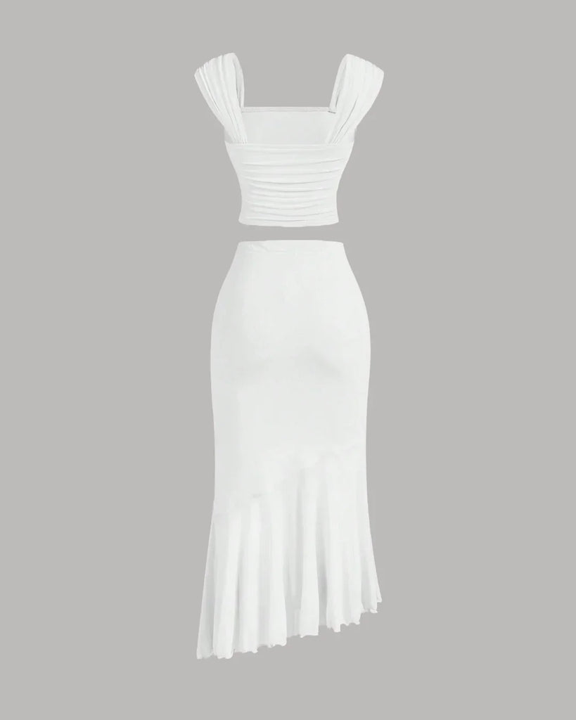 Back view of a White dress featuring a ruched crop top and an asymmetric hem skirt with a ruffled design.