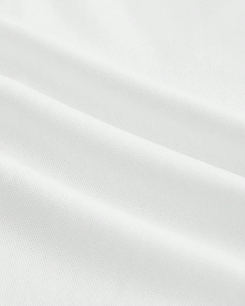 Closed view of a White dress featuring a ruched crop top and an asymmetric hem skirt with a ruffled design.