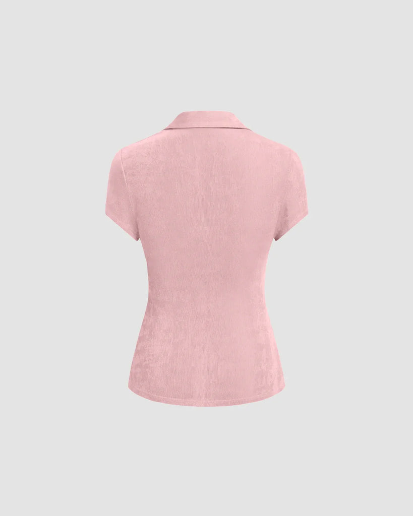 Back of a short sleeve dusty pink top with a ruched front and pointed collar, showcasing a flattering silhouette