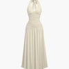 Ruched halter neck beige midi dress featuring a gathered bust and flowy silhouette with a standout backless detail.