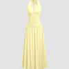 Ruched halter neck vanilla midi dress featuring a gathered bust and flowy silhouette with a standout backless detail.